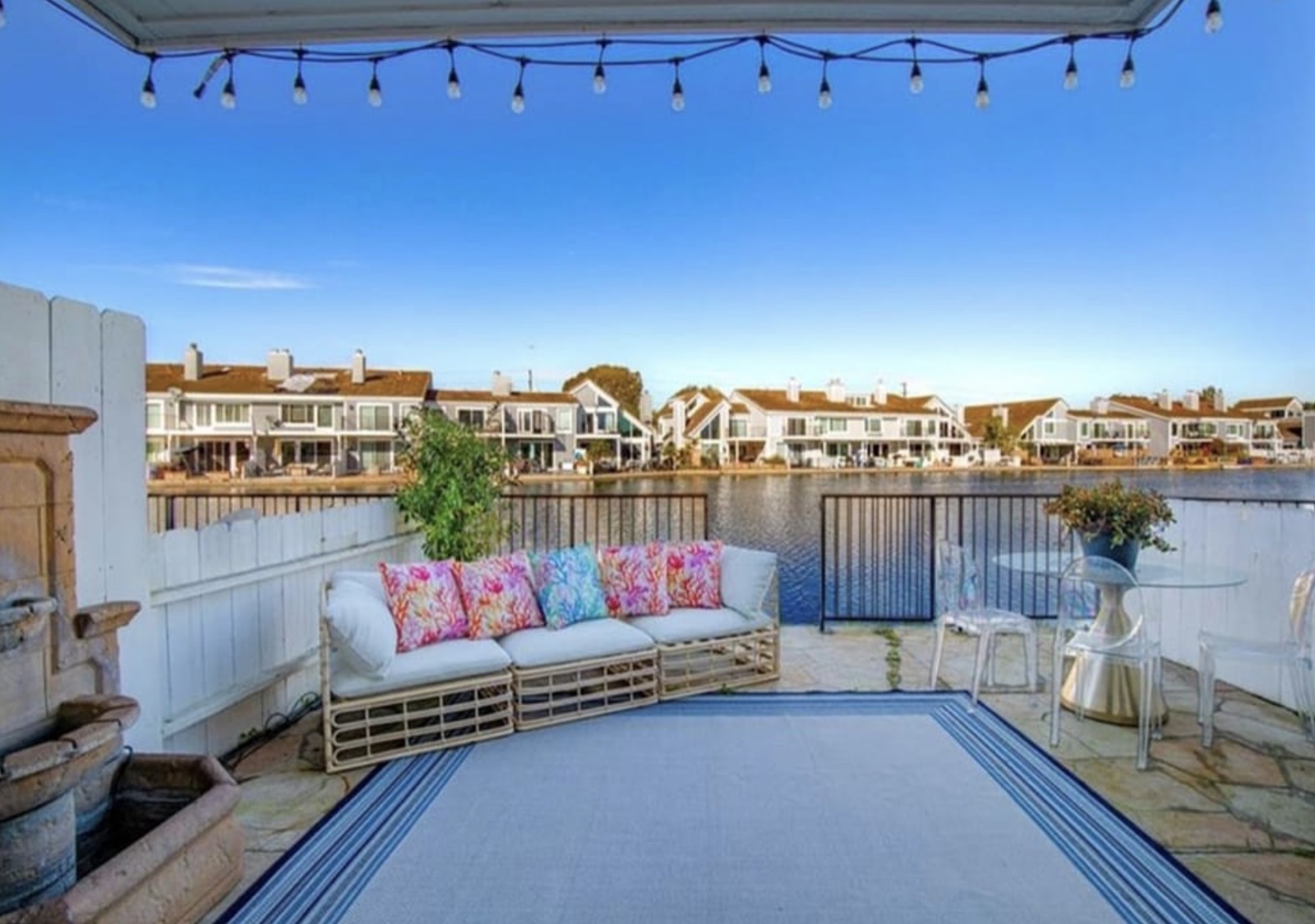 Waterfront backyard patio at 16104 Tortola Cir — string lights, harbour view, outdoor seating